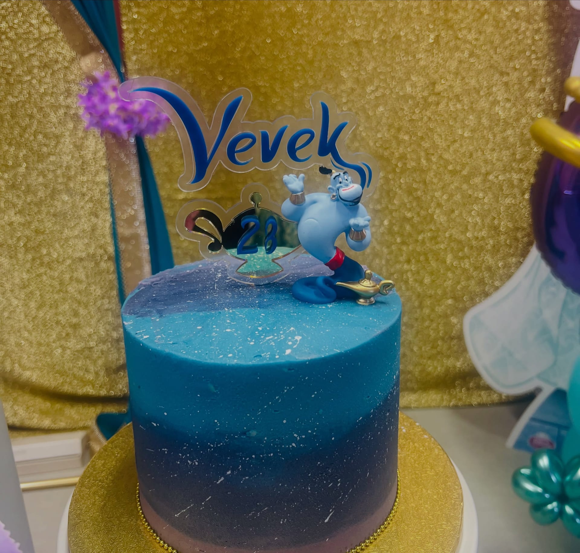 Blue ombre shimmer birthday cake with a genie topper and a personalised acrylic name