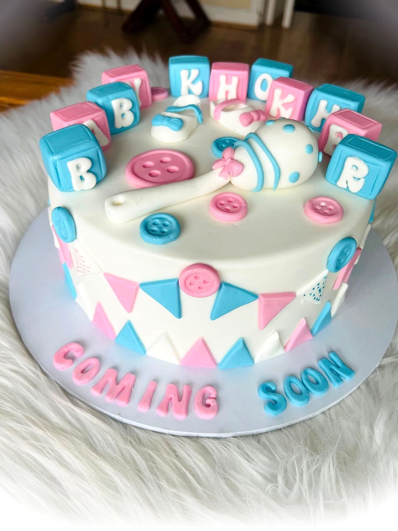 Baby Blocks Reveal Cake by SpongyBakes — A soft blue and pink cake with fondant blocks, bunting and buttons.