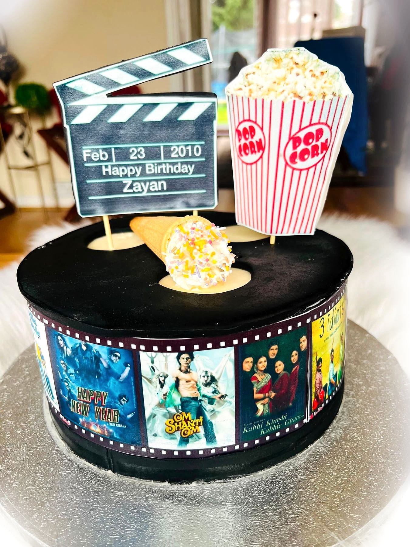 Movie Night Birthday Cake by SpongyBakes — A film-reel cake with a clapperboard topper and a popcorn box.
