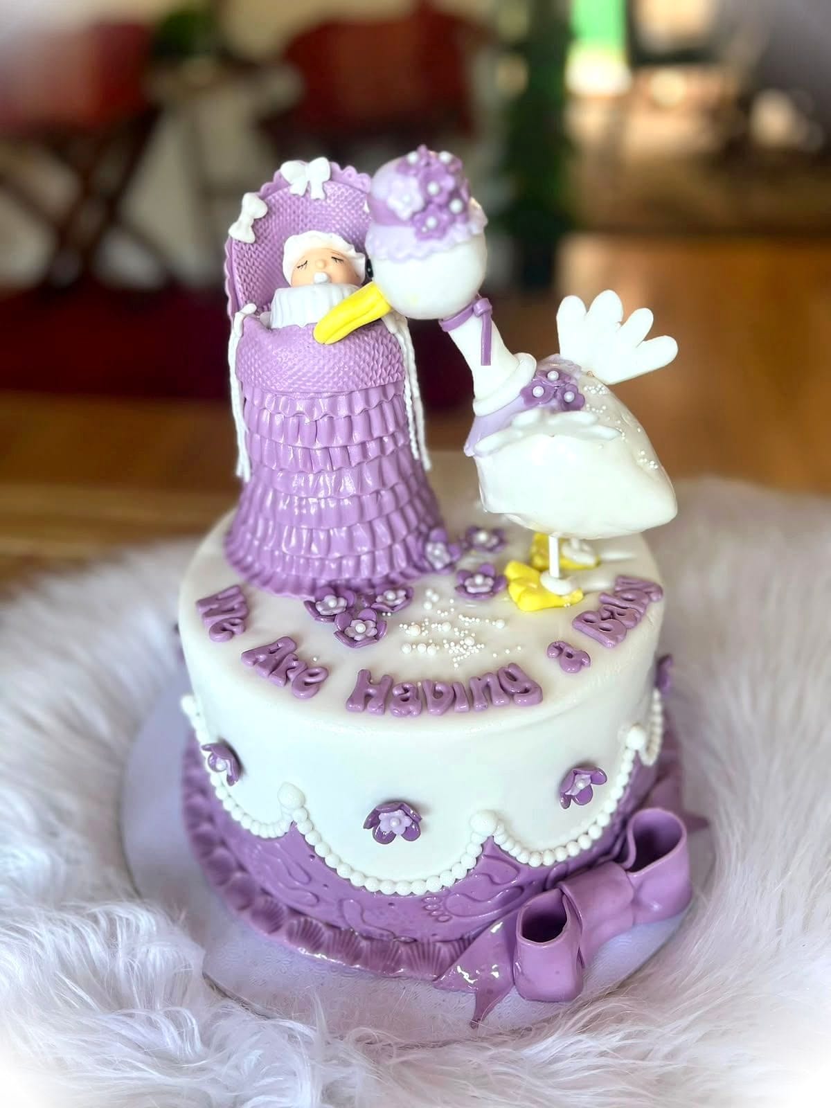 Stork Baby Shower Cake by SpongyBakes — A lilac cake with a hand-modelled stork, bundle and piped lace detailing.