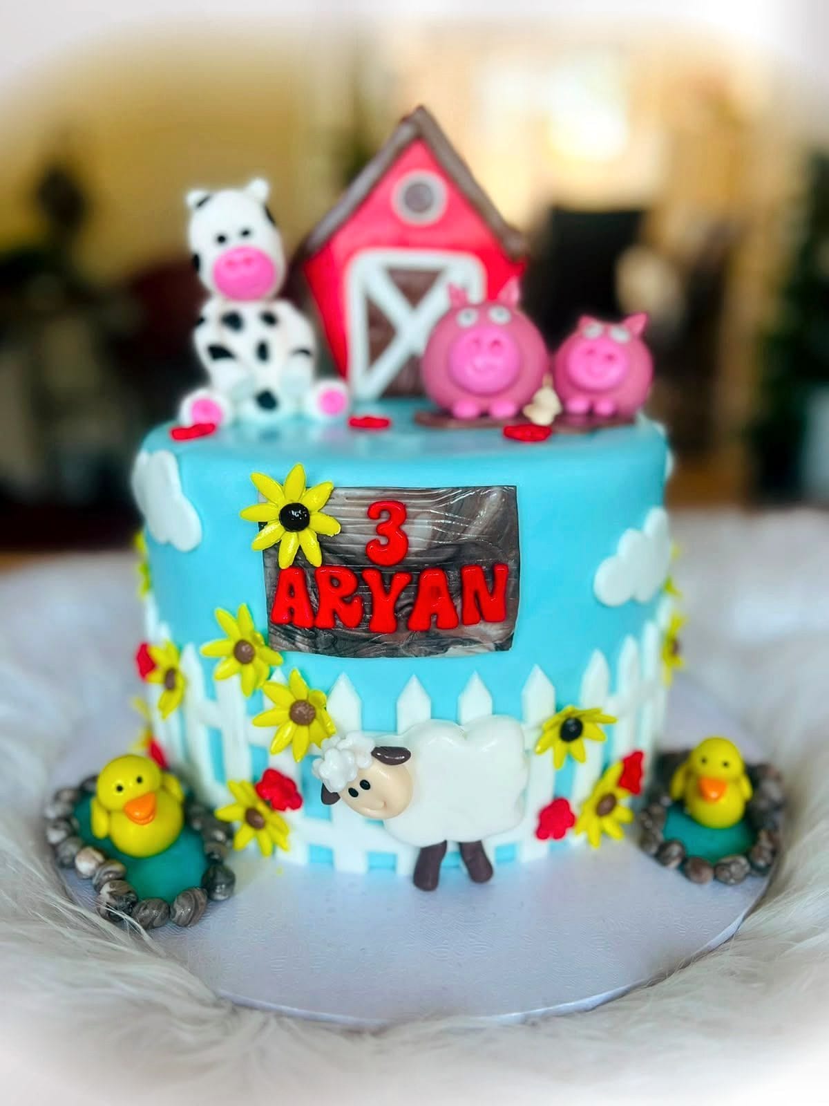 Farmyard Birthday Cake by SpongyBakes — A farm cake with a fondant barn, sunflowers, picket fence and animal toppers.