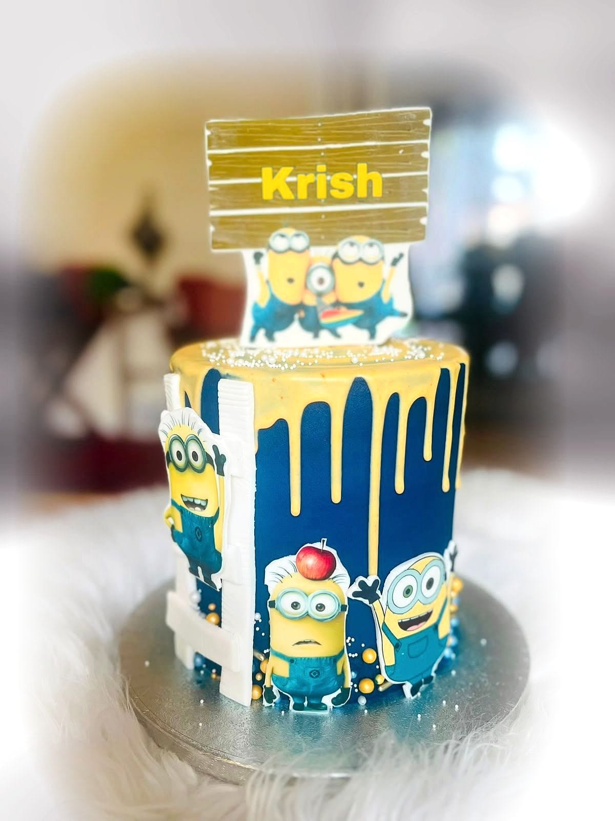 Yellow Character Drip Cake by SpongyBakes — A blue and yellow drip cake with printed character panels and an acrylic name topper.