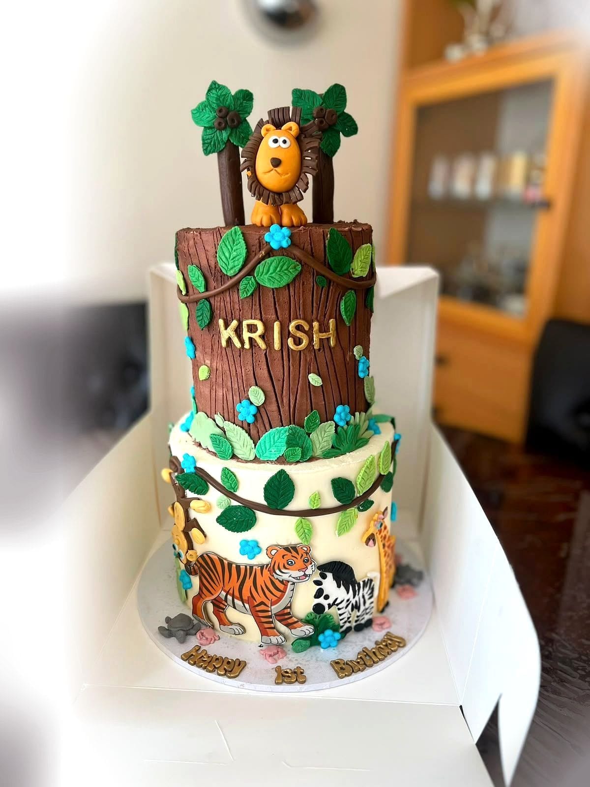 Jungle Two-Tier Birthday Cake by SpongyBakes — A two-tier jungle cake with a carved tree trunk, foliage and animal detailing.