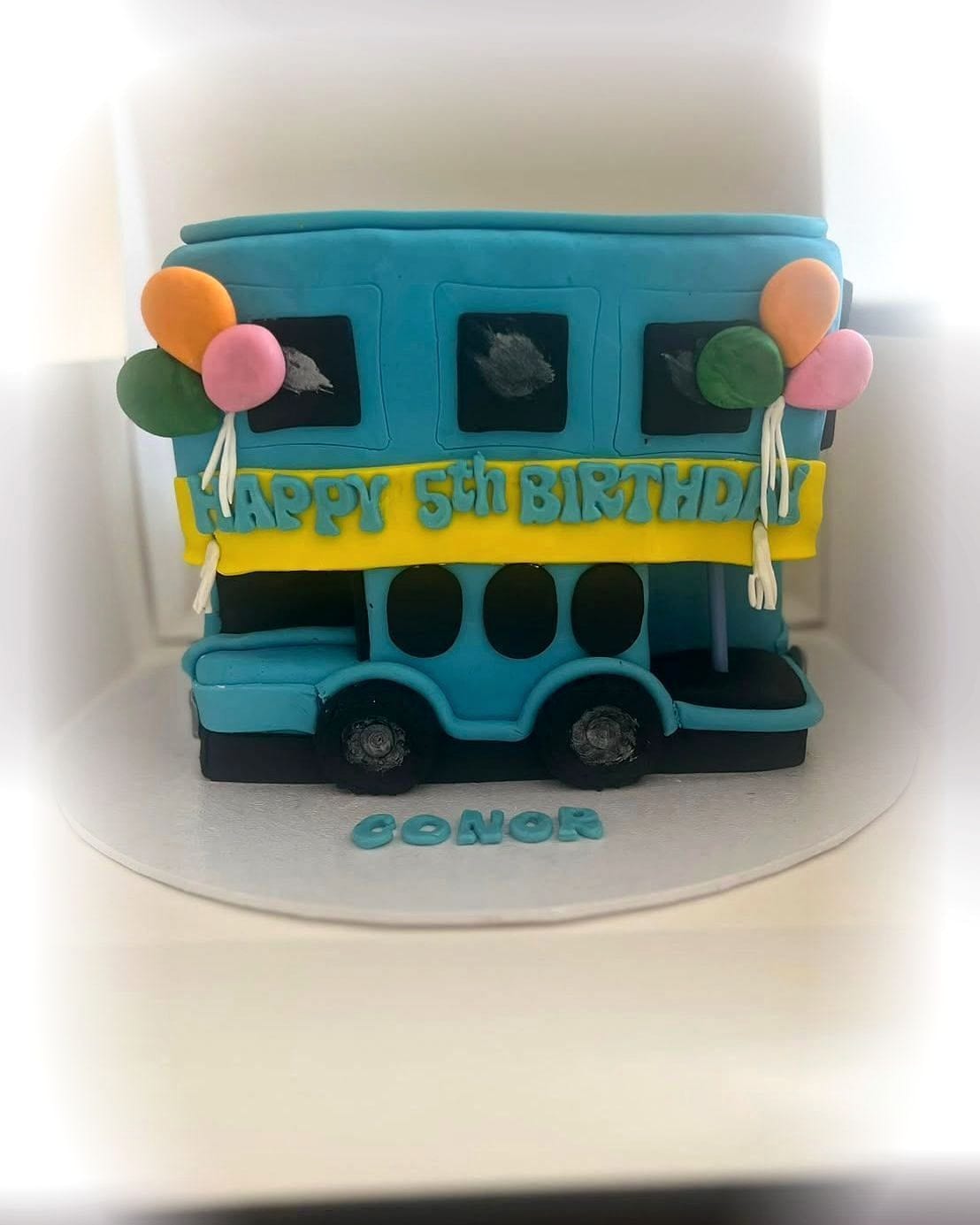 Blue Bus Sculpted Birthday Cake by SpongyBakes — A fully sculpted bus cake with fondant windows, balloons and piped lettering.
