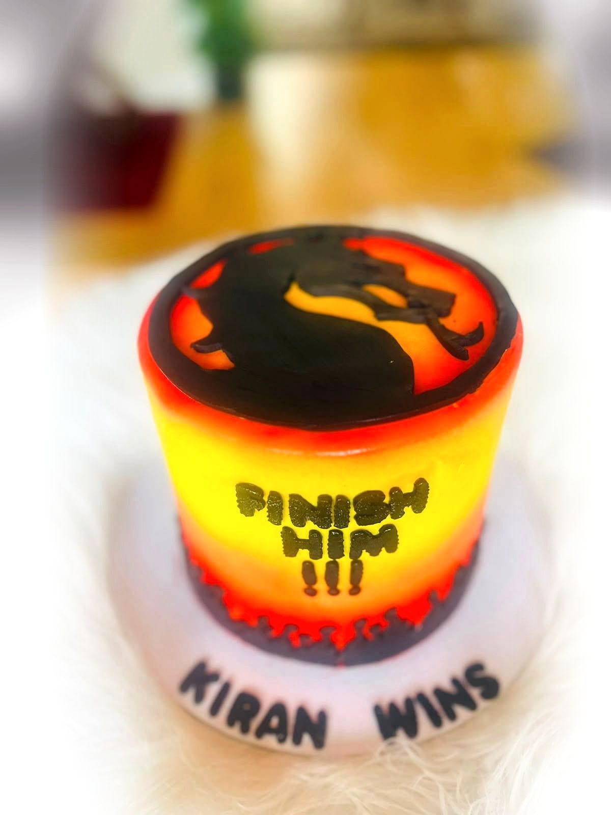 Gaming Battle Birthday Cake by SpongyBakes — A fire-toned gaming cake with a hand-painted emblem and piped lettering.