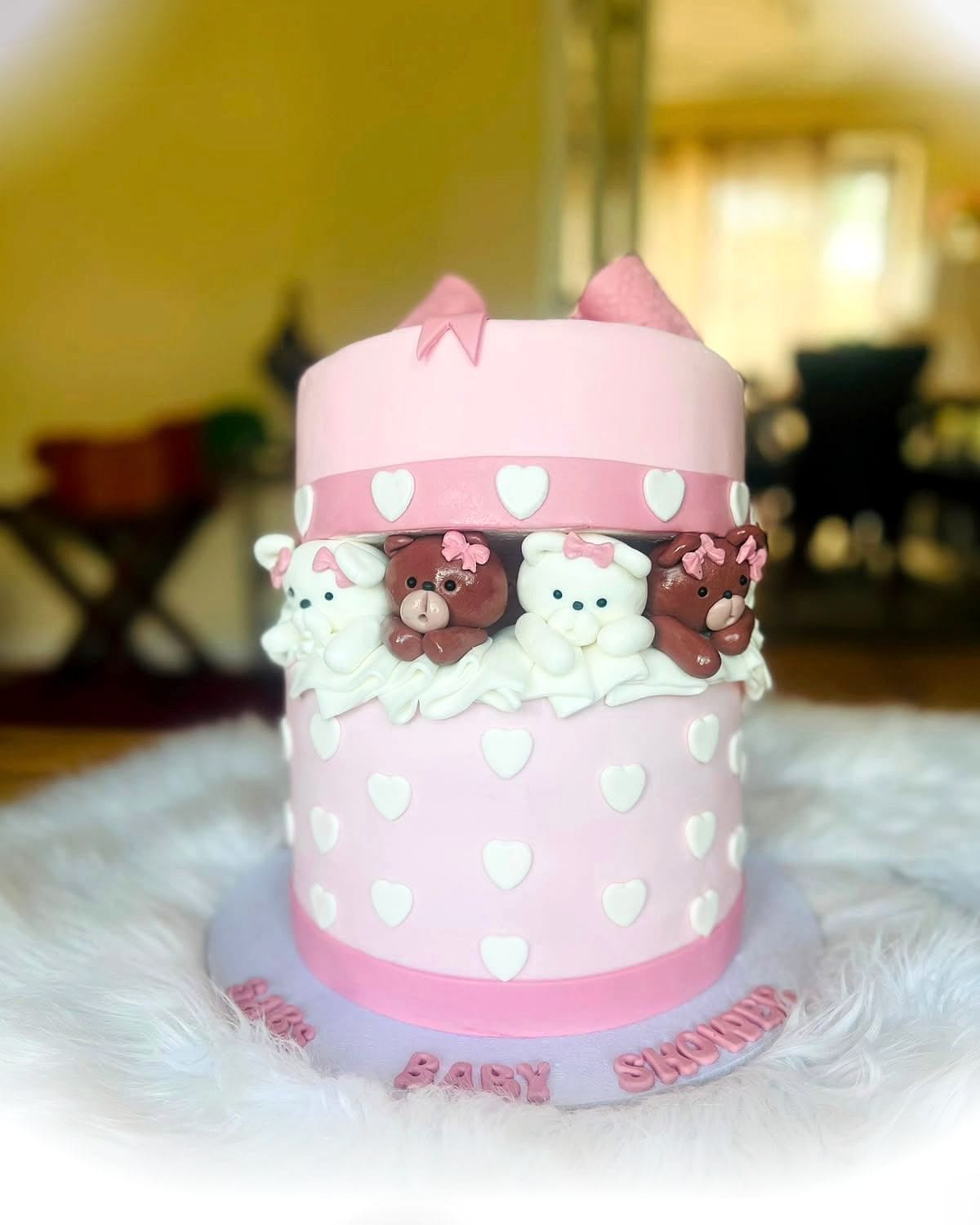 Teddy Bear Baby Cake by SpongyBakes — A pink heart-patterned cake with hand-modelled teddies and a fondant bow.