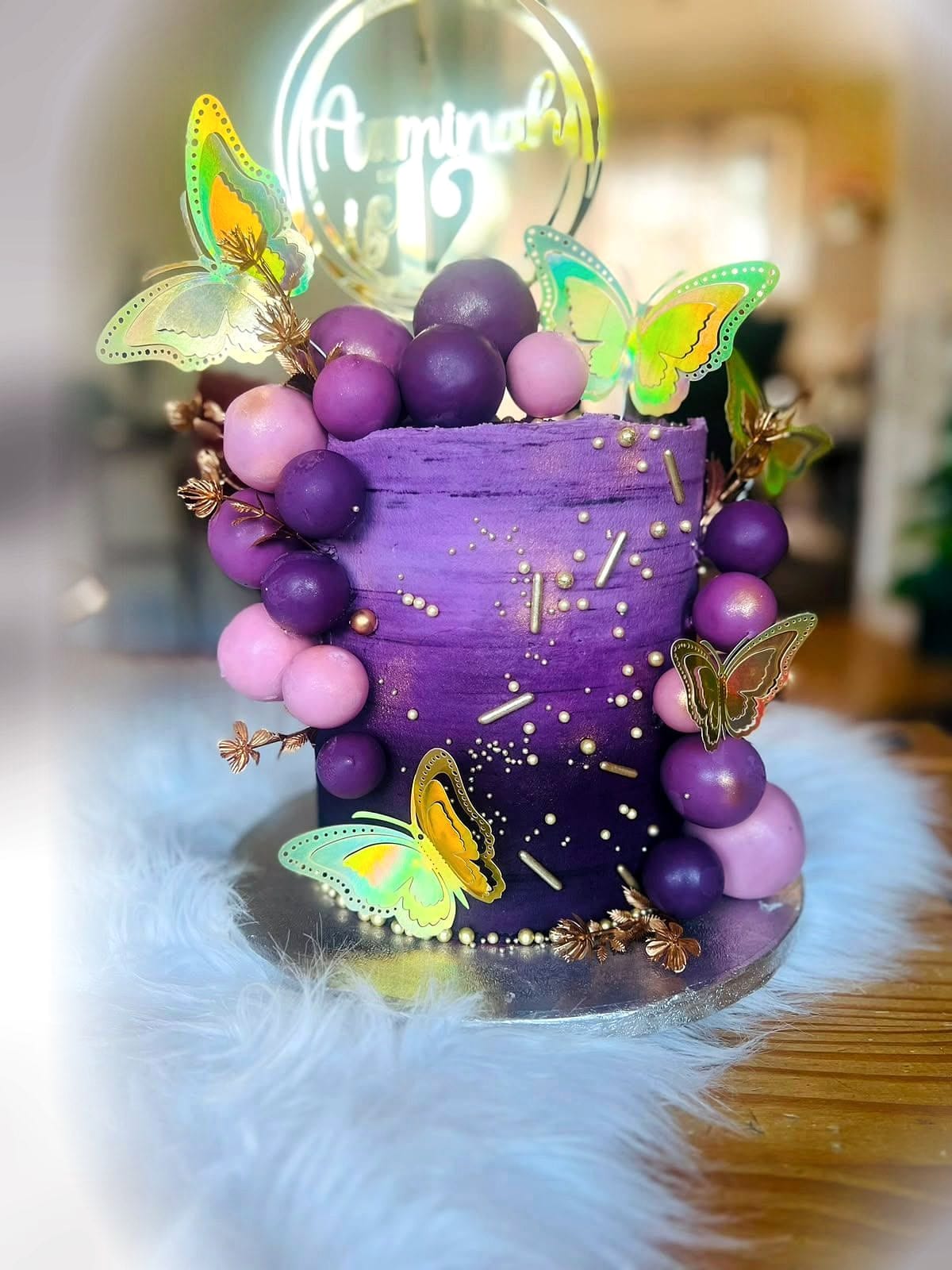 Purple Butterfly Birthday Cake by SpongyBakes — A purple cake with gold splatter, a chocolate sphere cluster and butterfly toppers.