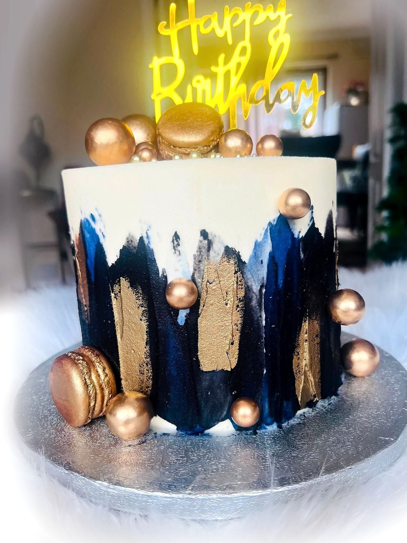 Navy & Gold Celebration Cake by SpongyBakes — An ivory cake with navy and gold brushwork, gold spheres and macarons.